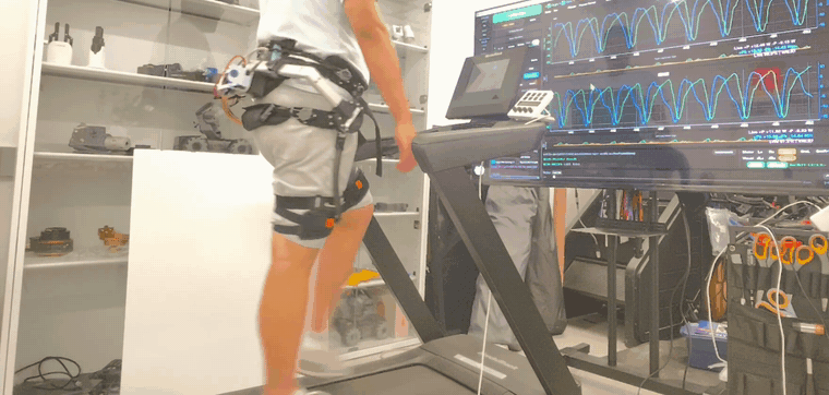 Participant walking on a treadmill while wearing the bilateral hip exoskeleton